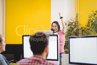 Graphic designer with raised arm in creative office