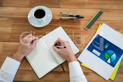 Businessman writing on a diary