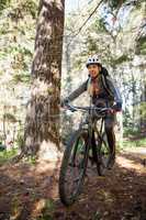 Female mountain biker riding bicycle in the forest