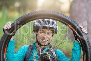 Portrait of female biker repairing mountain bike