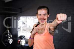 Smiling young woman punching in gym