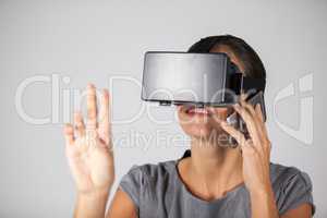 Woman talking on mobile phone while using virtual reality headset