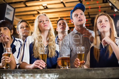 Upset fan watching football at bar counter