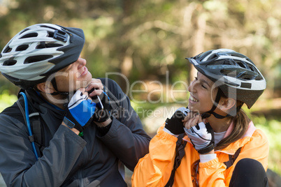 Biker couple wearing bicycle helmet in forest