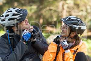 Biker couple wearing bicycle helmet in forest