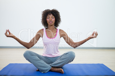 Woman doing meditation on exercise mat