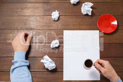 Man holding cup of coffee on paper