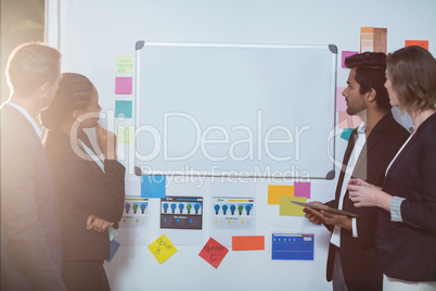 Group of businesspeople looking at whiteboard