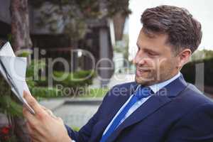 Handsome businessman reading newspaper