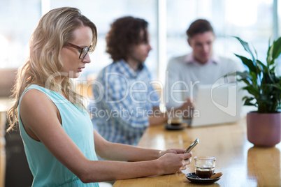 Woman using mobile phone in cafÃ?Â©