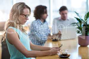 Woman using mobile phone in cafÃ?Â©