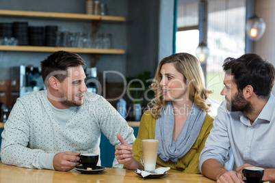 Friends interacting while have a cup of coffee