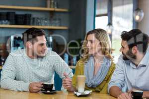 Friends interacting while have a cup of coffee