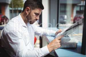Businessman reading newspaper in office