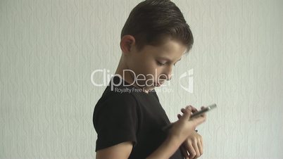 Young boy checking his  for the time on his wrist watch.
