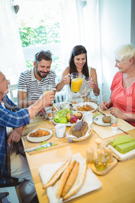 Happy couple having breakfast with their parents