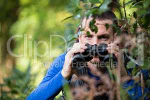 Male hiker looking through binoculars