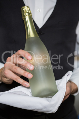 Bartender holding bottle of champagne in bar