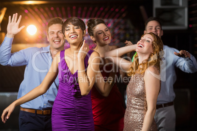 Smiling friends dancing on dance floor