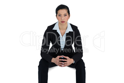 Confidence businesswoman sitting against white background
