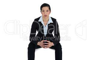 Confidence businesswoman sitting against white background