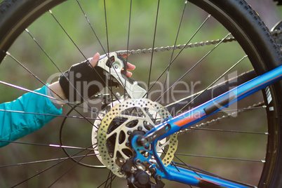 Hand of female biker repairing mountain bike