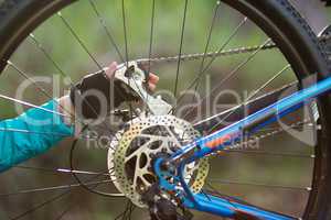 Hand of female biker repairing mountain bike
