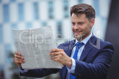 Handsome businessman reading newspaper