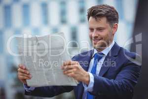 Handsome businessman reading newspaper