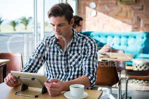 Man using digital tablet in coffee shop