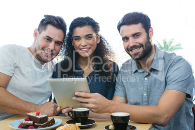 Three friends using a digital tablet