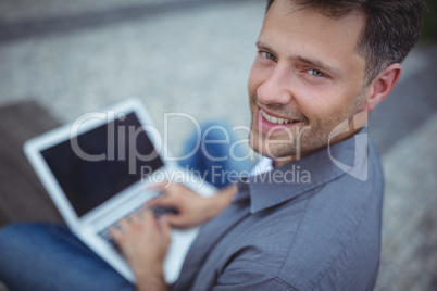 Portrait of handsome business executive using laptop