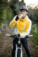 Male biker drinking water
