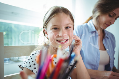 Smiling daughter sitting next to her mother