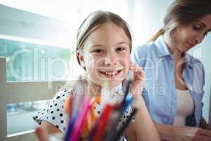 Smiling daughter sitting next to her mother