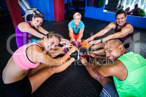 Portrait of smiling of friends stretching in gym