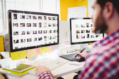 Cropped image of editor working on photographs at creative office