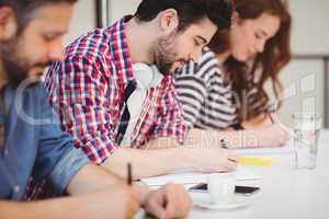 Creative businessman with coworkers writing on documents