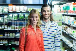Happy couple standing in supermarket