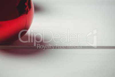 Red christmas bauble on wooden table