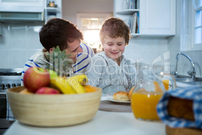 Father and son having breakfast in the kitchen