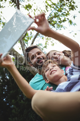 Father and kids taking a selfie with digital tablet