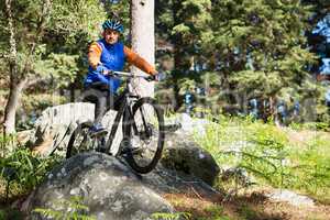 Male mountain biker riding bicycle in the forest