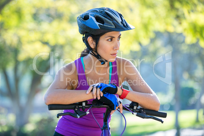 Female athletic leaning on bicycle in countryside
