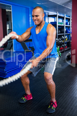 Athlete exercising with ropes in fitness studio