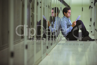 Technician siting on chair and using digital tablet