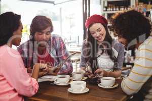 Group of friends using mobile phone and digital tablet