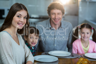 Portrait of happy family sitting on a dinning table