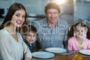 Portrait of happy family sitting on a dinning table