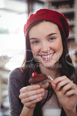 Portrait of smiling woman holding cupcake